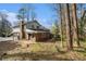Back exterior featuring brick, siding, mature trees, access to the back deck, and a partially fenced-in yard at 1677 Foresta Ct, Atlanta, GA 30341