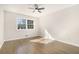 Inviting bedroom with a ceiling fan and hardwood floors illuminated by natural light through a large window at 1677 Foresta Ct, Atlanta, GA 30341