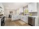Modern kitchen with white cabinets, stainless steel appliances, and a view into the dining area at 1677 Foresta Ct, Atlanta, GA 30341