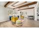 Cozy living room featuring decorative beams, a plush sofa, and modern furniture with connecting dining area at 1677 Foresta Ct, Atlanta, GA 30341