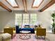 Sunlit living room boasts wood beam ceiling and a large window with a comfortable sofa and colorful decor at 1677 Foresta Ct, Atlanta, GA 30341