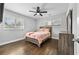 Inviting bedroom with a floral patterned bedspread, ceiling fan, wood floors, and natural light at 2587 Lancaster Dr, Atlanta, GA 30344