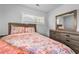 Well-lit bedroom with natural light, a patterned bedspread, wood floors, and a dresser at 2587 Lancaster Dr, Atlanta, GA 30344
