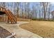 Multi-tiered backyard with a concrete patio and stairs to the upper level at 3211 Blaisdell Rd, Buford, GA 30519