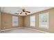 Spacious bedroom features neutral walls, carpeted floors, and three windows for natural light at 3211 Blaisdell Rd, Buford, GA 30519