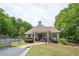 View of the community clubhouse, with pool access, manicured lawns, and sign: Gathering Recreation Area Residents Only at 3211 Blaisdell Rd, Buford, GA 30519