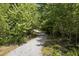 Long gravel driveway with natural surroundings and dense trees offer a private entrance to the property at 3211 Blaisdell Rd, Buford, GA 30519