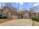 Attractive one-story brick home with a spacious driveway, showcasing its inviting curb appeal and convenient two-car garage at 3211 Blaisdell Rd, Buford, GA 30519