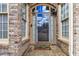 Inviting front entrance with a glass-paneled door, complemented by brick accents and a charming welcome mat at 3211 Blaisdell Rd, Buford, GA 30519