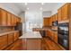 Well-lit kitchen showcasing wooden cabinets, appliances, central island, and wood floors at 3211 Blaisdell Rd, Buford, GA 30519