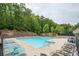 Community pool surrounded by ample lounge chairs and mature trees at 3211 Blaisdell Rd, Buford, GA 30519