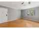 Bright living room boasts a ceiling fan, window, hardwood floors, and neutral paint at 1508 Wingate Way, Atlanta, GA 30350