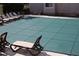 Outdoor pool covered with a protective net, surrounded by lounge chairs at 1508 Wingate Way, Atlanta, GA 30350