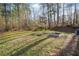 The large backyard features raised garden beds, mature trees, and ample space for outdoor activities at 2285 Briarwood Trl, Cumming, GA 30041