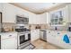 Charming kitchen features white cabinets, stainless appliances, granite counters, and a bright window view at 2285 Briarwood Trl, Cumming, GA 30041