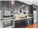 Close-up of a kitchen with stainless steel appliances, granite countertops, and dark wood cabinetry at 270 17Th Nw St # 4208, Atlanta, GA 30363