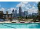 Enjoy the condo complex outdoor pool with city skyline views, surrounded by lush greenery and comfortable lounge chairs at 270 17Th Nw St # 4208, Atlanta, GA 30363