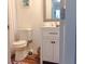 Cozy bathroom features a white vanity, toilet, decorative mirror and light fixture, with wood-look floors at 3065 Wildflower Ln, Snellville, GA 30039