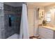 Full bathroom includes tiled shower with decorative tile accent, white vanity and storage, and wood-look flooring at 3065 Wildflower Ln, Snellville, GA 30039