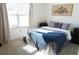 Inviting bedroom with soft natural light, stylish decor, and a comfortable bed dressed with a blue throw blanket at 3065 Wildflower Ln, Snellville, GA 30039