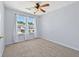 This cozy carpeted bedroom features a ceiling fan and a window that provides natural light at 695 Georgetown Ct, Jonesboro, GA 30236