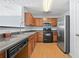 Functional kitchen with stainless steel appliances, wooden cabinets, and laminate flooring at 695 Georgetown Ct, Jonesboro, GA 30236