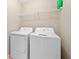 A well-lit laundry room features a washer, dryer, and a shelf for storage at 695 Georgetown Ct, Jonesboro, GA 30236