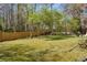 A large backyard with mature trees and a wooden fence at 2073 Lou Ct, Grayson, GA 30017