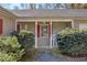 Close-up of a cozy front porch featuring a white chair, lush bushes, and a charming entrance at 2073 Lou Ct, Grayson, GA 30017