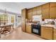 Functional kitchen with wood cabinets, laminate countertop and black appliances, and a dining area for casual meals at 2073 Lou Ct, Grayson, GA 30017