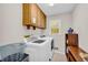 Bright laundry room with modern machines, cabinets, and natural light from the window at 2073 Lou Ct, Grayson, GA 30017