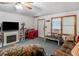 Living room featuring carpet, sofa, chair, fireplace, and decor at 2643 Rocky Creek Rd, Hampton, GA 30228