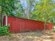 A large, red outbuilding with ample storage space, surrounded by trees and vegetation at 2643 Rocky Creek Rd, Hampton, GA 30228