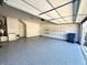 Spacious garage featuring epoxy floors, overhead door, and wall-mounted shelving for storage at 310 Ellington Dr, Canton, GA 30115