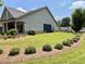 Well-maintained side yard with lush green grass, manicured hedges, and a charming porch at 310 Ellington Dr, Canton, GA 30115