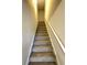 Carpeted stairway with a white railing and neutral walls at 310 Ellington Dr, Canton, GA 30115