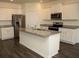 Modern kitchen featuring a center island, stainless steel appliances, and white cabinetry at 443 Faulkner St, Stockbridge, GA 30281