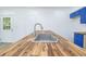 Up-close view of kitchen island with butcher block countertop, stainless steel sink, and blue cabinets at 451 Collier Ridge Dr, Atlanta, GA 30318