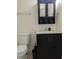 A bathroom vanity features dark cabinetry and a white countertop with a toilet and decorative items at 6980 Roswell Rd # E11, Atlanta, GA 30328