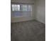 A naturally lit bedroom with plush carpet and a large window at 6980 Roswell Rd # E11, Atlanta, GA 30328