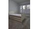 A simple bedroom features a daybed and a window with blinds at 6980 Roswell Rd # E11, Atlanta, GA 30328