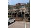 Townhome complex with brick facade, balconies, stairs, and parking, set amidst mature trees at 6980 Roswell Rd # E11, Atlanta, GA 30328