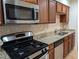 Well-lit kitchen with stainless steel appliances, granite countertops, and wood cabinets, perfect for cooking enthusiasts at 6980 Roswell Rd # E11, Atlanta, GA 30328