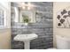 Charming powder room with rustic wood paneling, pedestal sink, and stylish mirror at 2600 Cohassett Ct, Decatur, GA 30034
