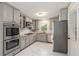 Modern kitchen featuring stainless steel appliances, sleek gray cabinetry, and granite countertops at 2600 Cohassett Ct, Decatur, GA 30034
