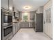 Well-lit kitchen with stainless steel appliances, gray cabinets, and granite countertops at 2600 Cohassett Ct, Decatur, GA 30034