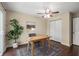 Bright home office featuring a ceiling fan, desk, chair, area rug, and a door leading to other spaces at 2600 Cohassett Ct, Decatur, GA 30034