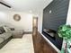 Modern living room with hardwood floors, a cozy gray sectional, and a striking black electric fireplace accent wall at 147 Hermer Nw Cir, Atlanta, GA 30311