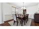 Bright dining room with wood floors, modern chandelier, and classic wainscoting at 1595 Johnstown Trace, Suwanee, GA 30024