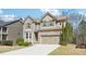 Beautiful two-story home featuring a brick facade, two-car garage, and lush green lawn at 1595 Johnstown Trace, Suwanee, GA 30024